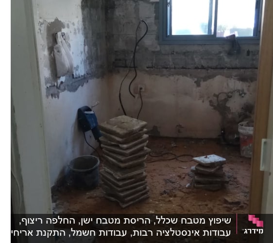 חדר בשיפוץ עם ערימות אריחים על הרצפה